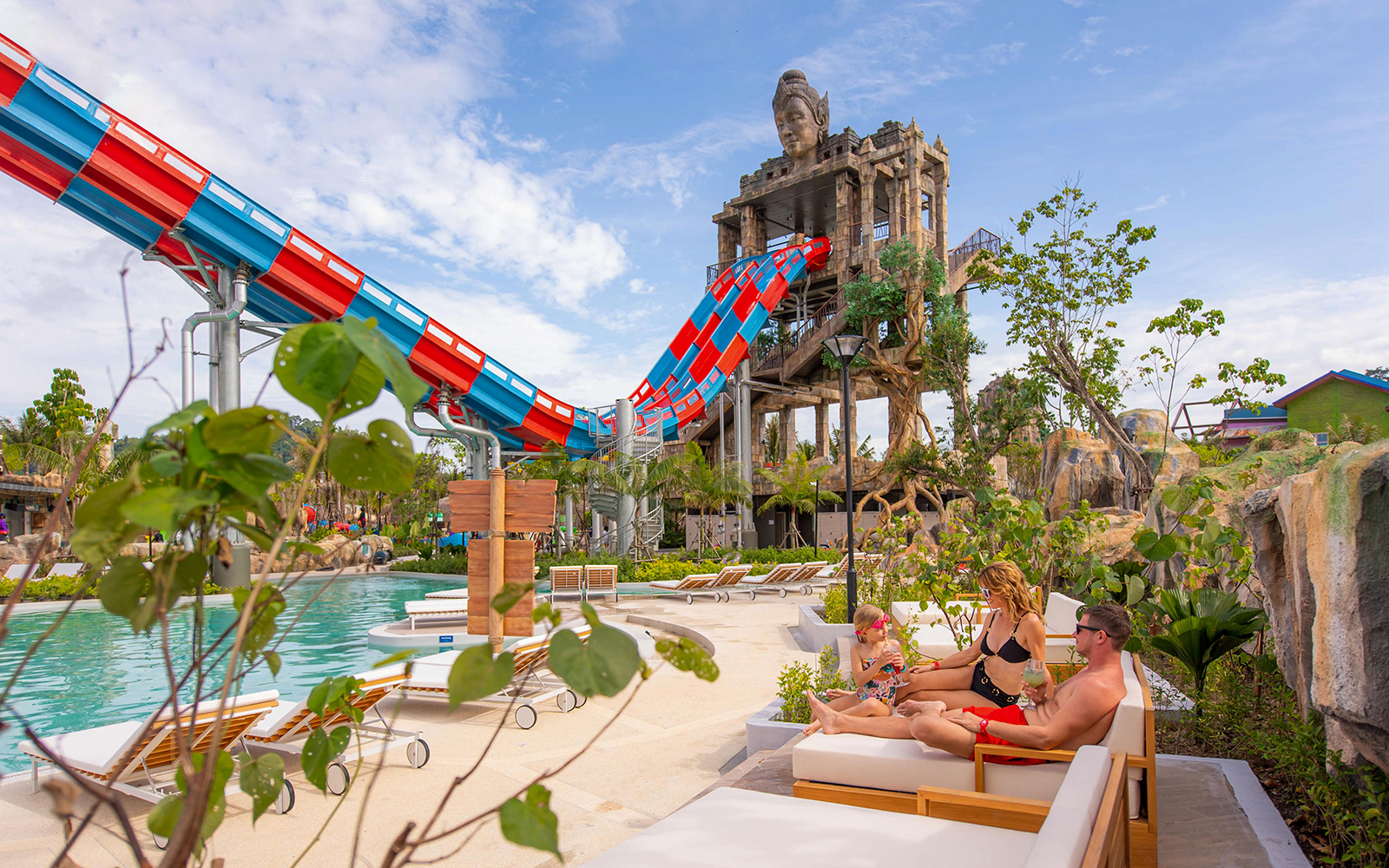 Family relaxing on deck chairs near the Emerald Forest ride at Andamanda Phuket.