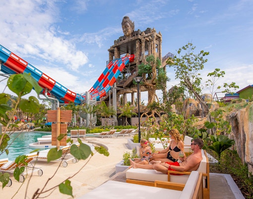 Family relaxing on deck chairs near the Emerald Forest ride at Andamanda Phuket.