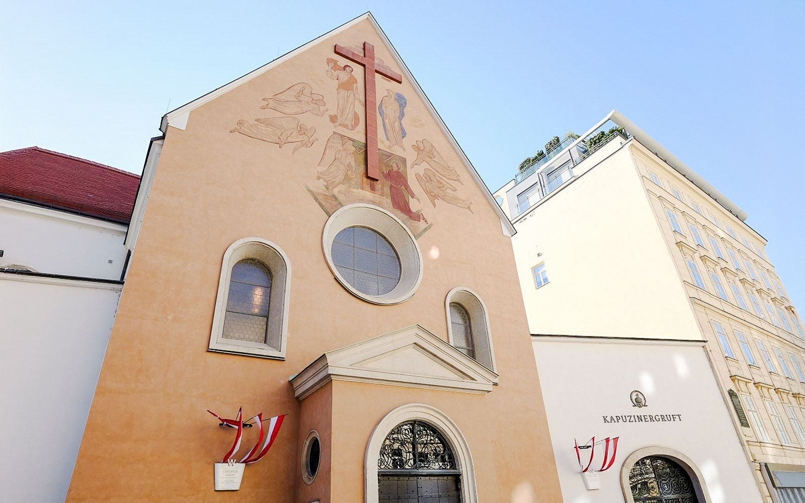 Minoritenkirche facade with fresco and cross in Vienna, Austria.