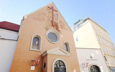Minoritenkirche facade with fresco and cross in Vienna, Austria.