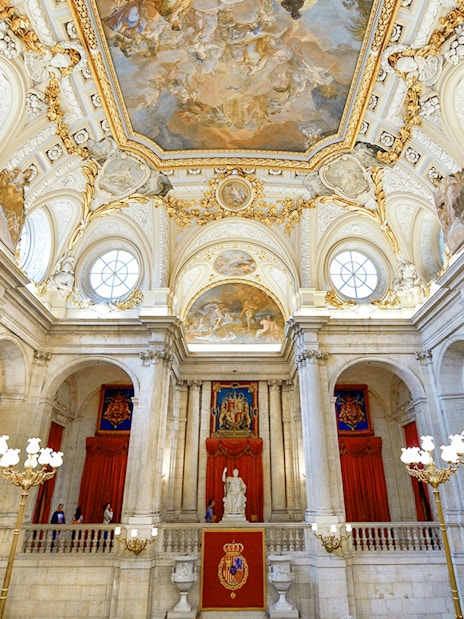 Royal Palace of Madrid interior with ornate ceiling and grand staircase.
