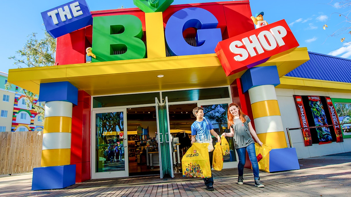 Visitors exiting The Big Shop at LEGOLAND Theme Park, Florida with LEGO bags.