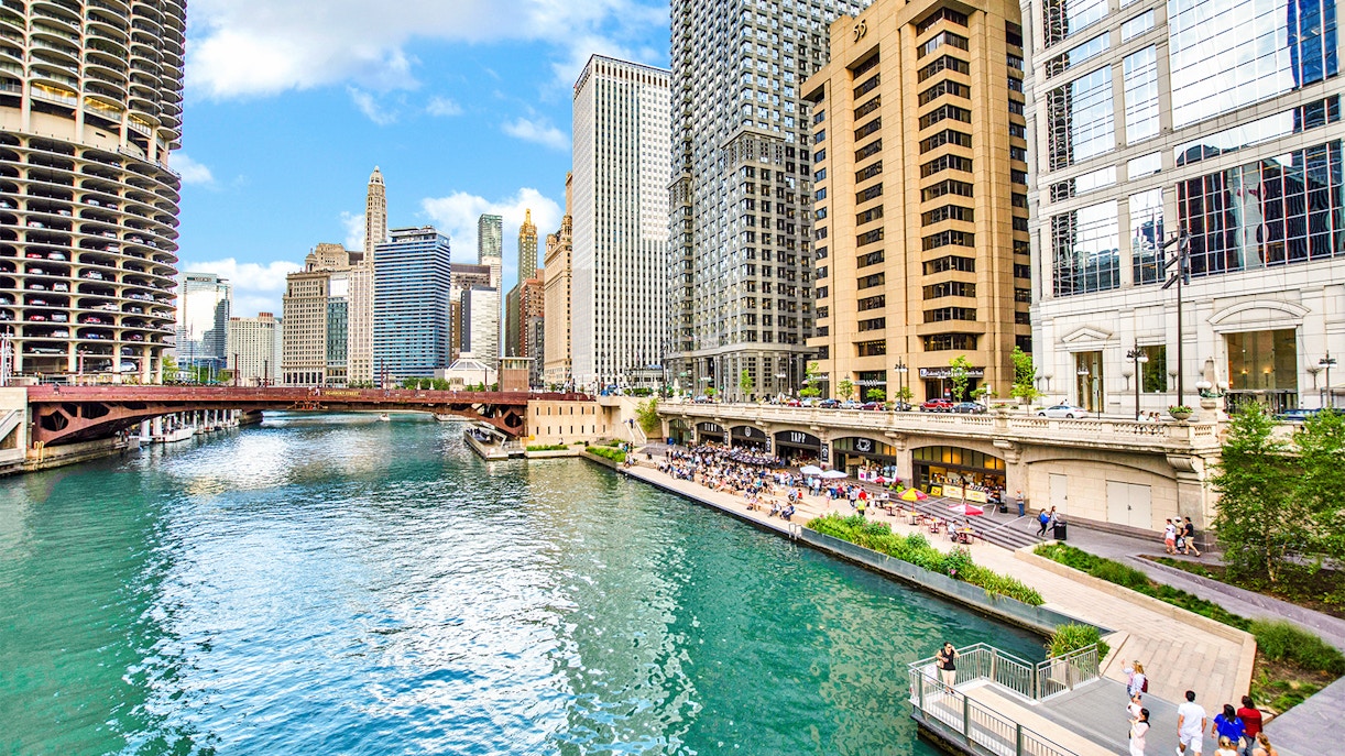 Chicago Riverwalk with skyscrapers and bridge in the background.