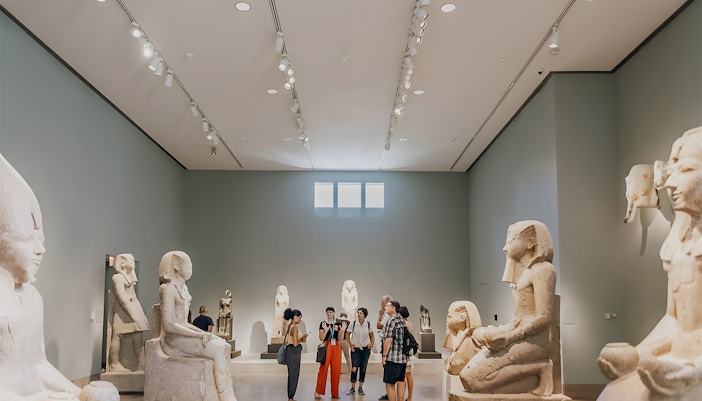 Guide interacting with tourist in New York's Metropolitan Museum of Art during an extended guided tour.