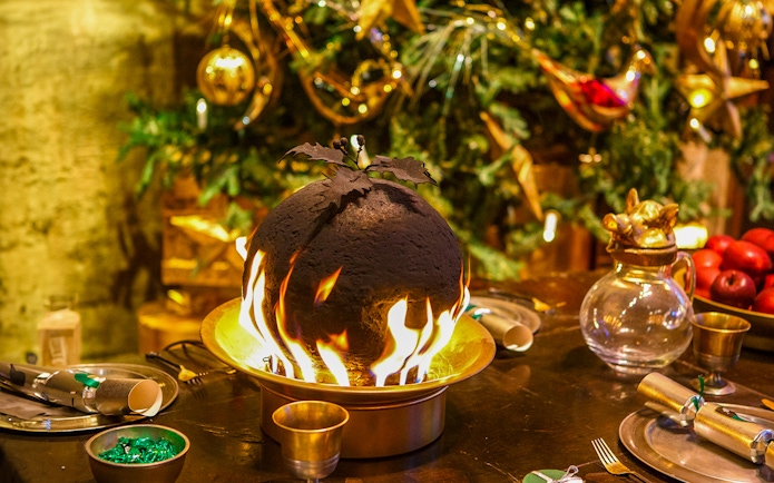 Flaming Christmas pudding on a festive table at Hogwarts.