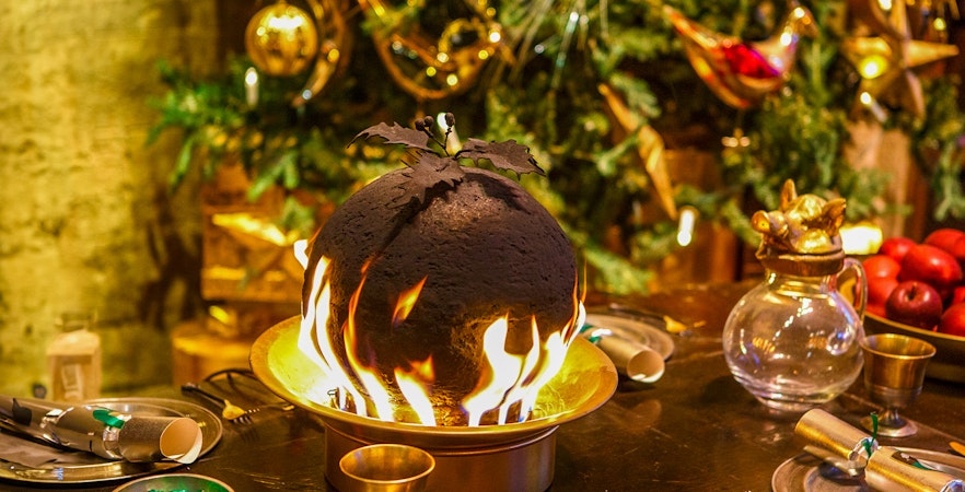 Flaming Christmas pudding on a festive table at Hogwarts.