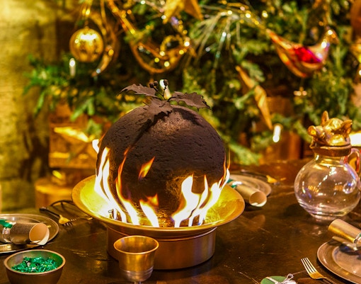 Flaming Christmas pudding on a festive table at Hogwarts.