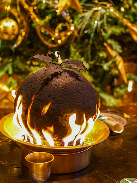 Flaming Christmas pudding on a festive table at Hogwarts.
