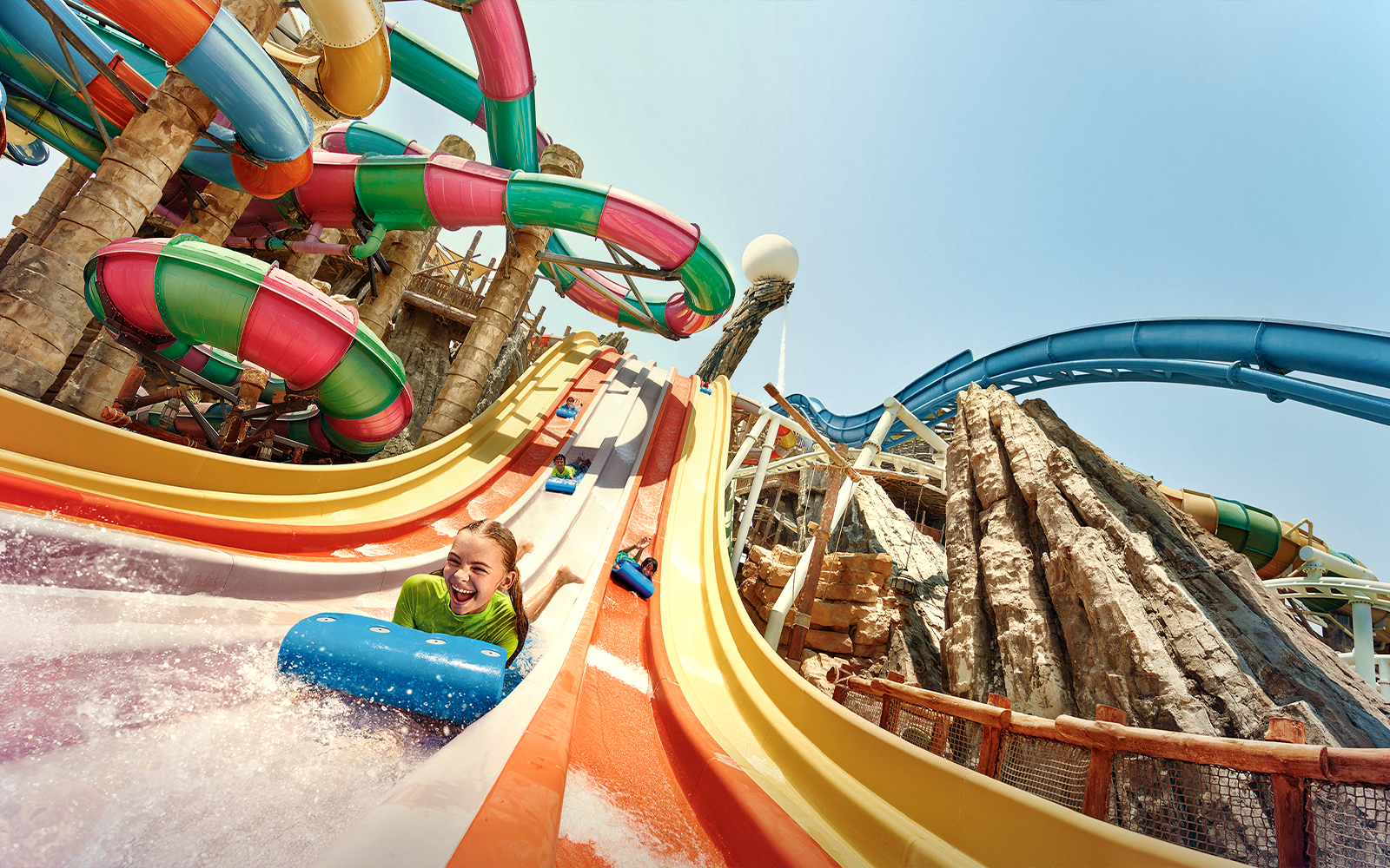 Visitors enjoying colorful water slides at Yas Waterworld, Abu Dhabi.