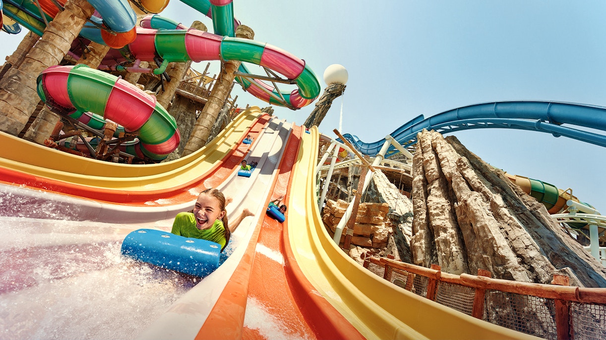 Visitors enjoying colorful water slides at Yas Waterworld, Abu Dhabi.