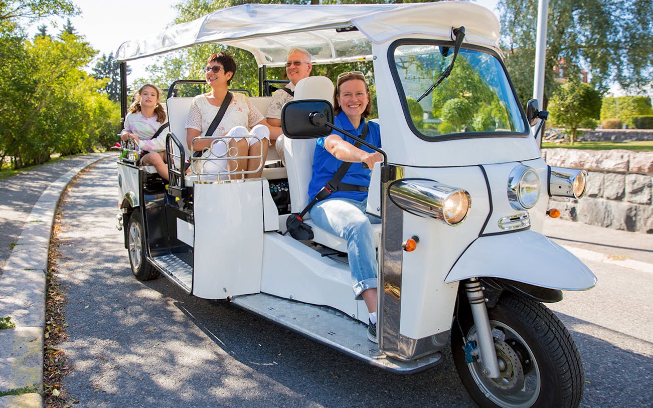Tuk Tuk tour with passengers exploring Valencia's scenic streets.