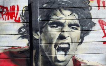 Mural of a passionate soccer player on a wall in La Paternal, Buenos Aires.