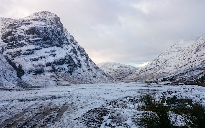 Snow-covered mountains in Glencoe, Scotland during winter.