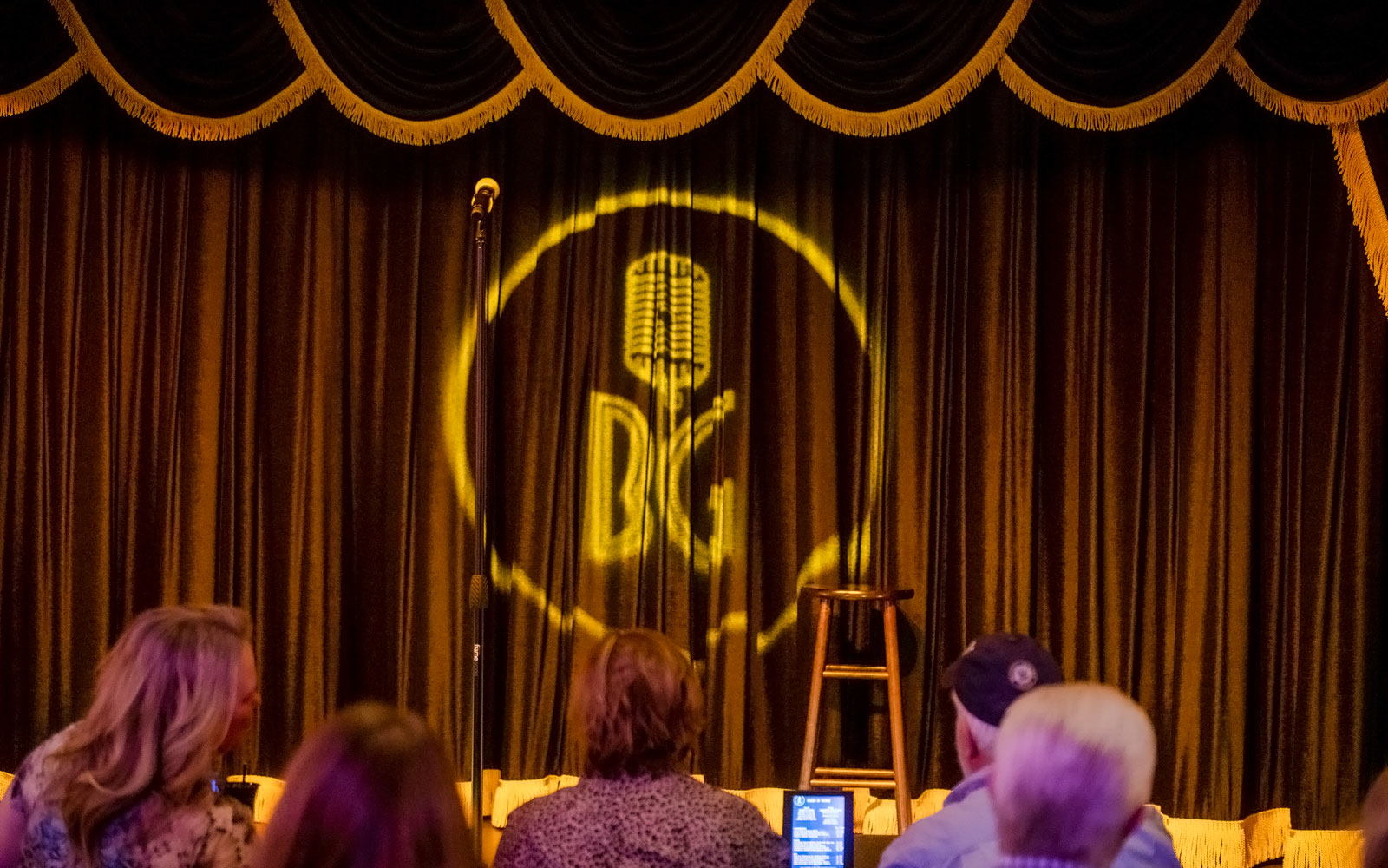 Stage setup at Brad Garrett's comedy club in Vegas with microphone and stool.