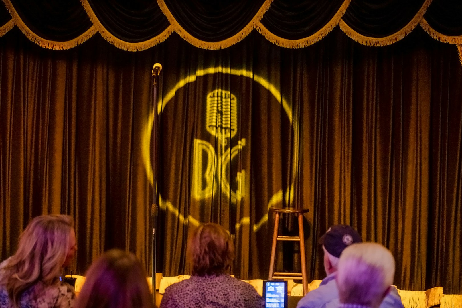 Stage setup at Brad Garrett's comedy club in Vegas with microphone and stool.
