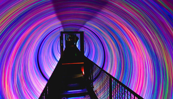 Camera Obscura Edinburgh rooftop view with tourists observing cityscape.