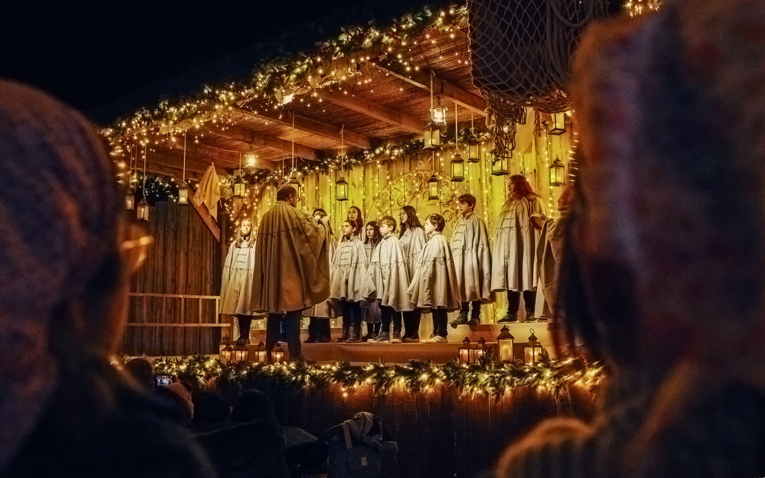 Carol singing show at Puy du Fou España during Christmas with choir on decorated stage.