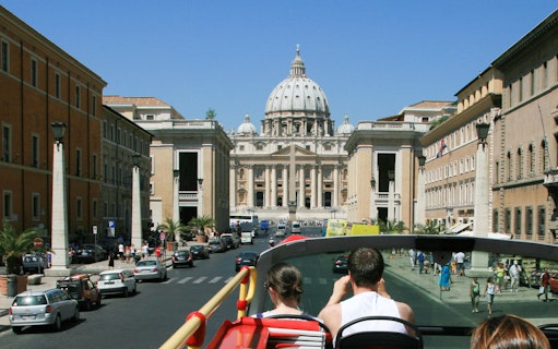 Tourists on a bus approaching St. Peter's Basilica in Vatican City.