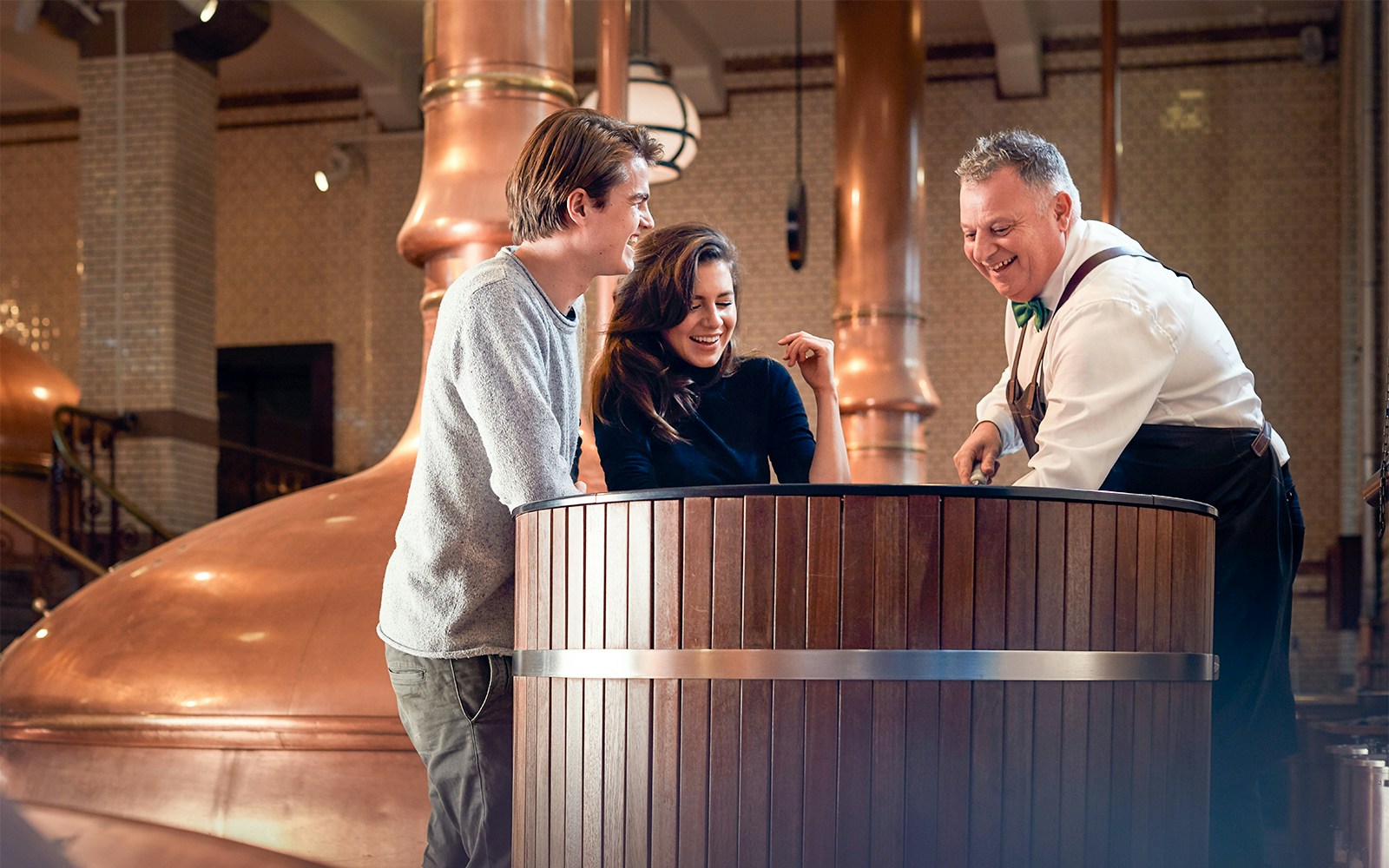 Heineken Experience tour entrance in Amsterdam with visitors exploring the brewery.