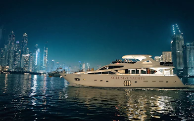 Luxury yacht cruising near Dubai Marina with city skyline in the background.
