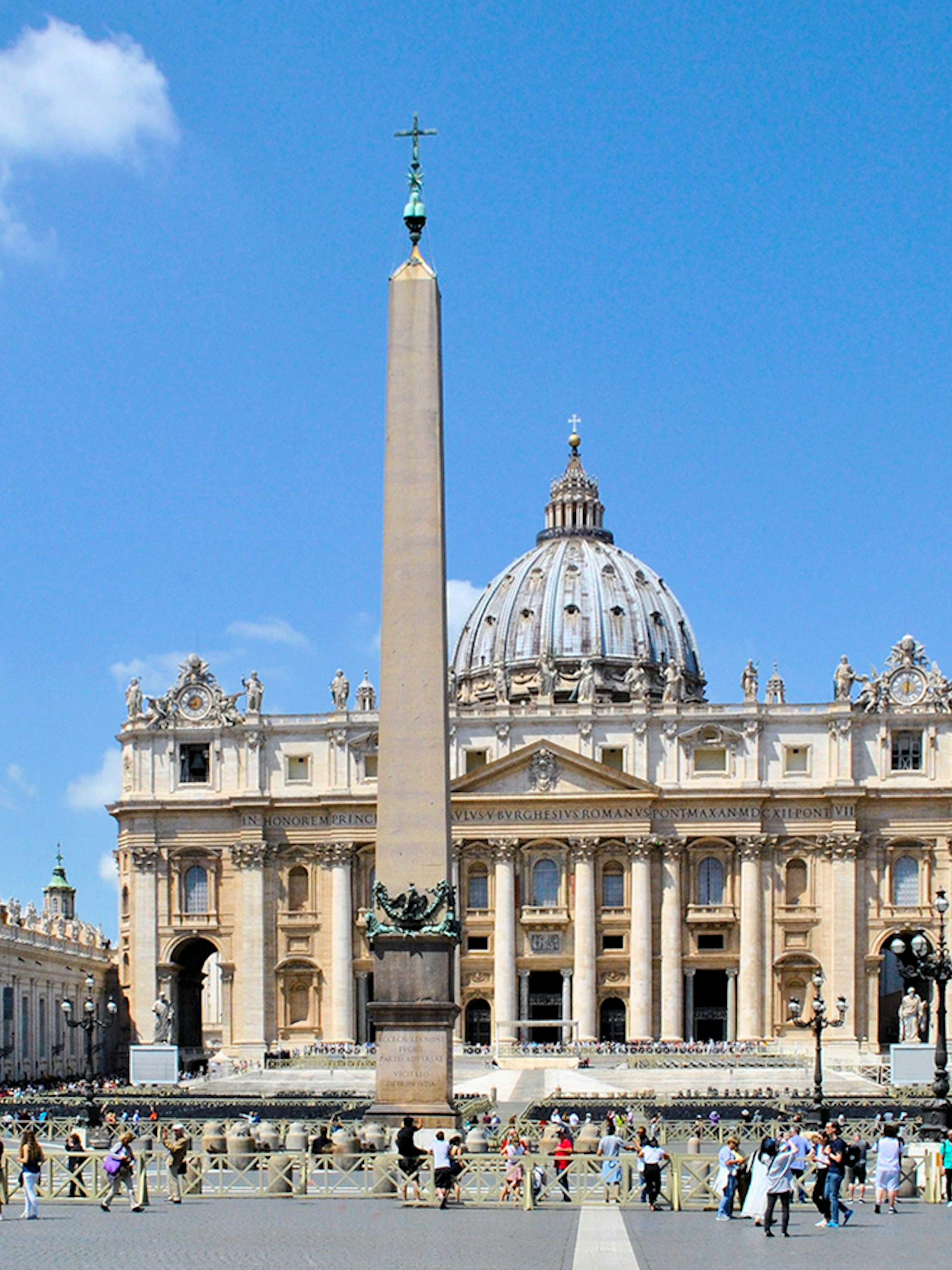 St. Peter's Basilica with obelisk in Vatican City, Rome, surrounded by tourists.