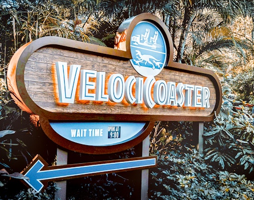 Velocicoaster entrance sign at Universal Orlando, Florida, surrounded by lush greenery.