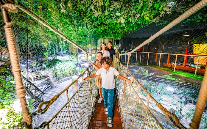 Family walking on a rope bridge in Dubai Aquarium.