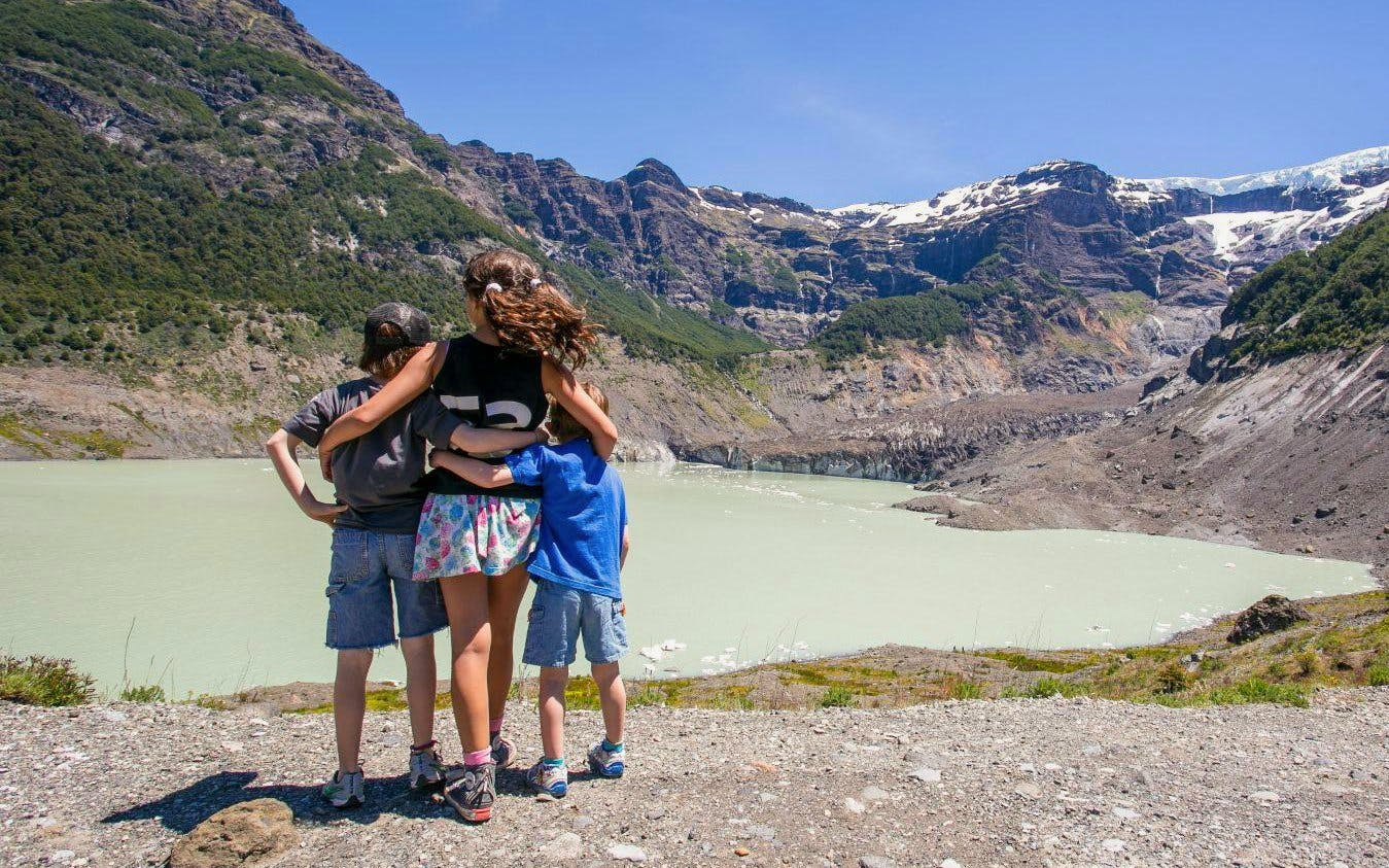 Family enjoying view of glacial lagoon and hanging glaciers at Mount Tronador, Argentina.