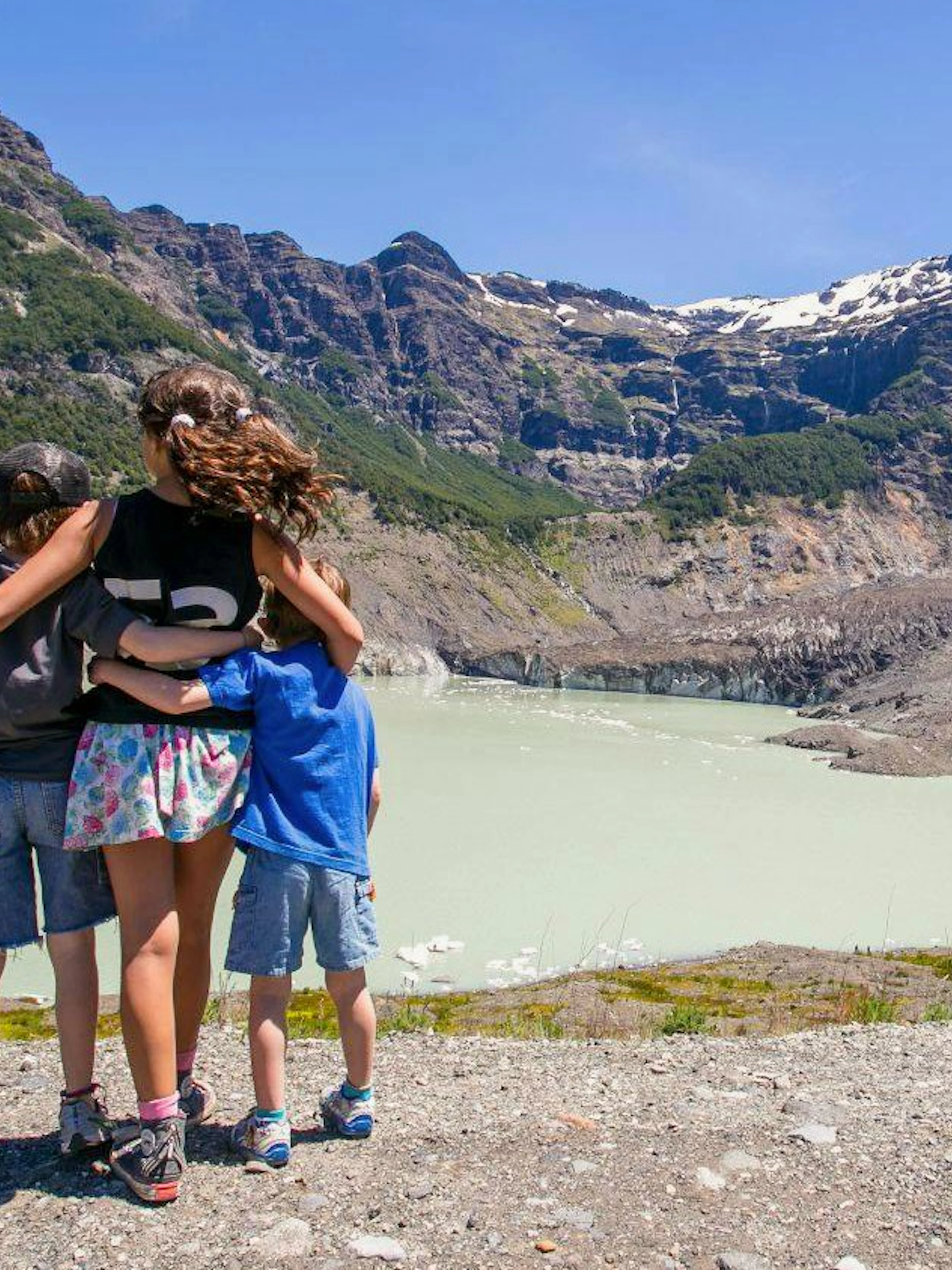 Family enjoying view of glacial lagoon and hanging glaciers at Mount Tronador, Argentina.