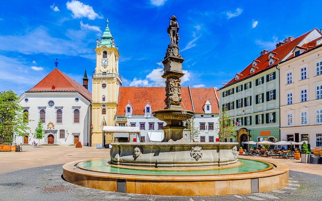 Maximilian Fountain in Bratislava's Main Square, Slovakia, with historic buildings.