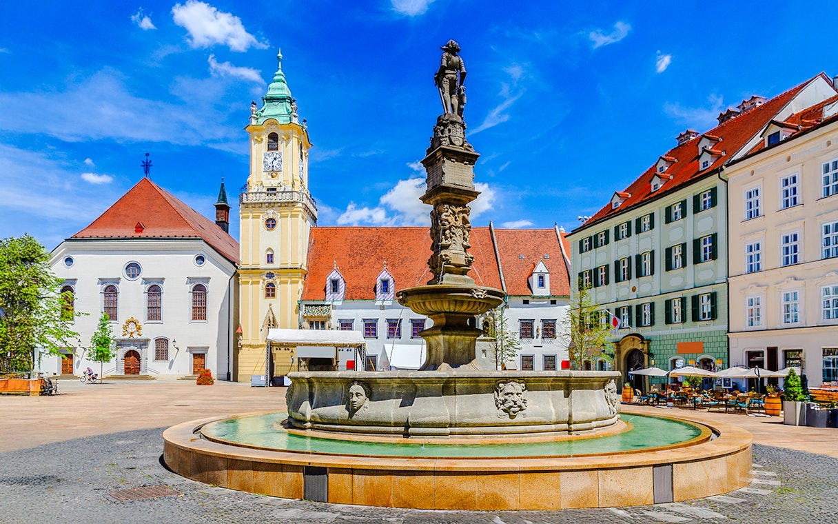Maximilian Fountain in Bratislava's Main Square, Slovakia, with historic buildings.
