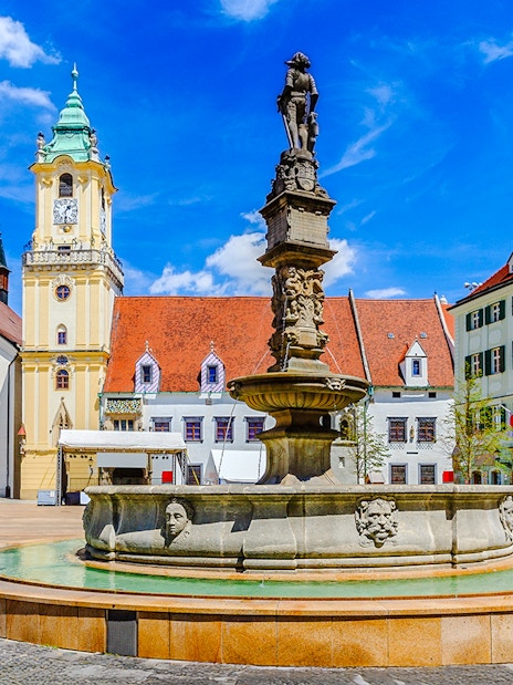 Maximilian Fountain in Bratislava's Main Square, Slovakia, with historic buildings.
