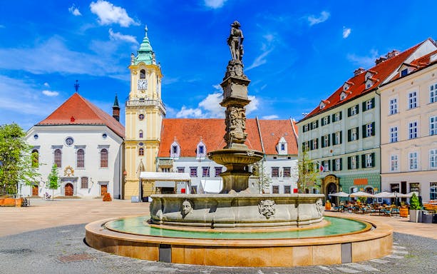 Maximilian Fountain in Bratislava's Main Square, Slovakia, with historic buildings.