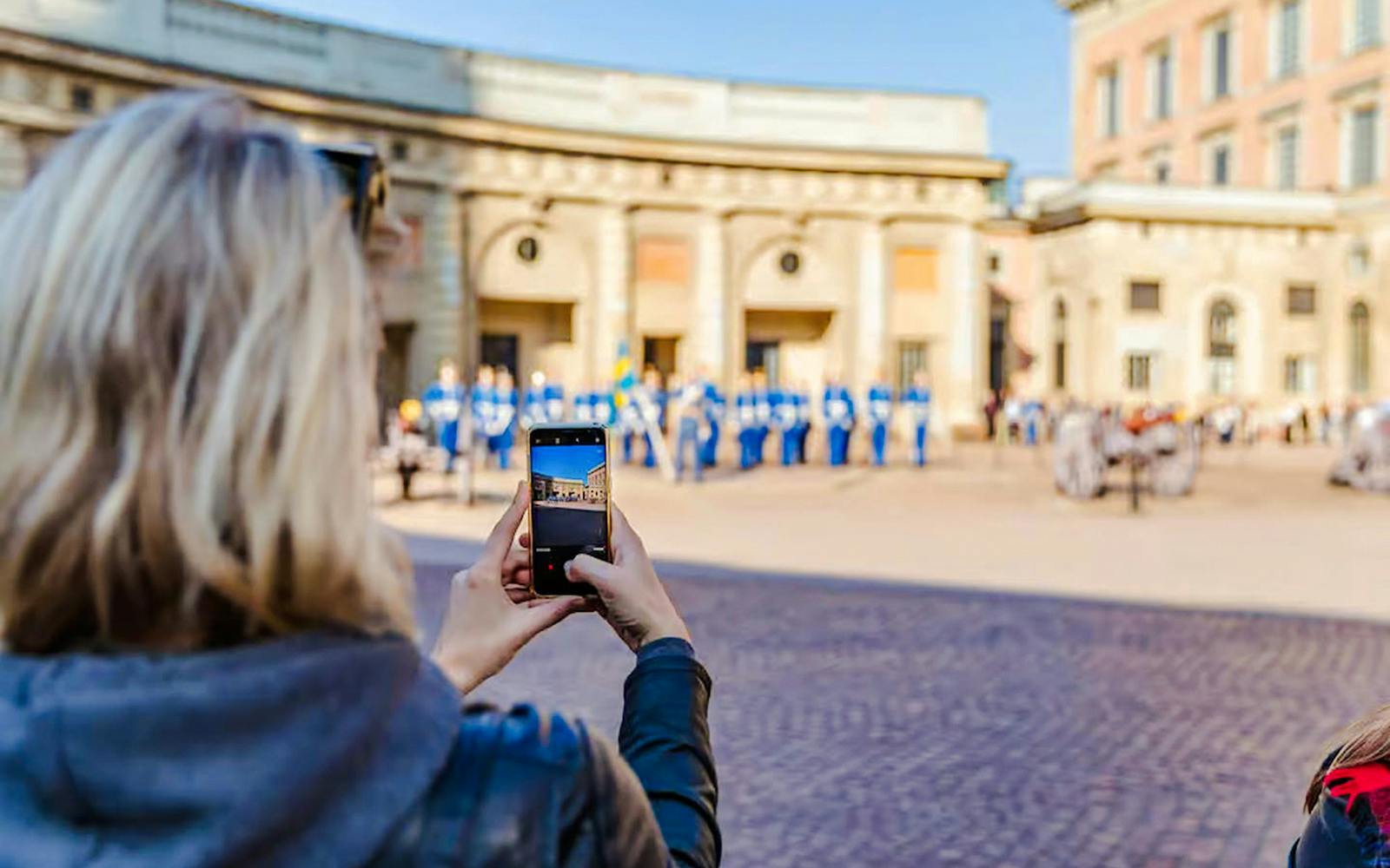 Person photographing Changing of the Guard ceremony at Royal Palace, Stockholm.