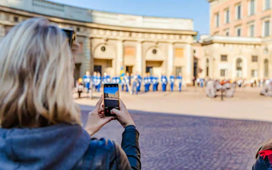 Person photographing Changing of the Guard ceremony at Royal Palace, Stockholm.