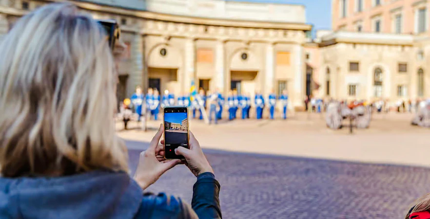 Person photographing Changing of the Guard ceremony at Royal Palace, Stockholm.
