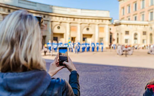 Person photographing Changing of the Guard ceremony at Royal Palace, Stockholm.