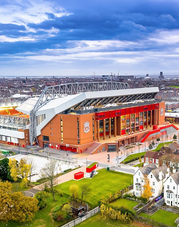 Liverpool FC stadium aerial view, showcasing the iconic red exterior and surrounding cityscape.