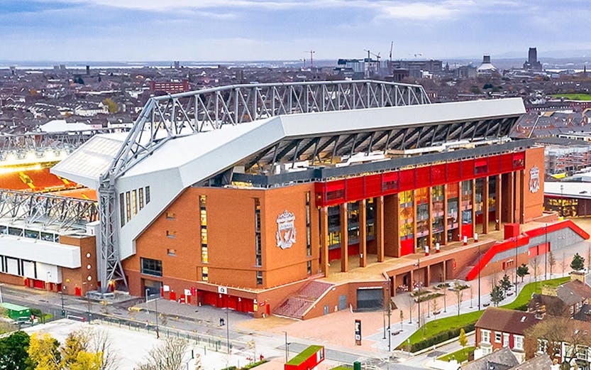 Liverpool FC stadium aerial view, showcasing the iconic red exterior and surrounding cityscape.