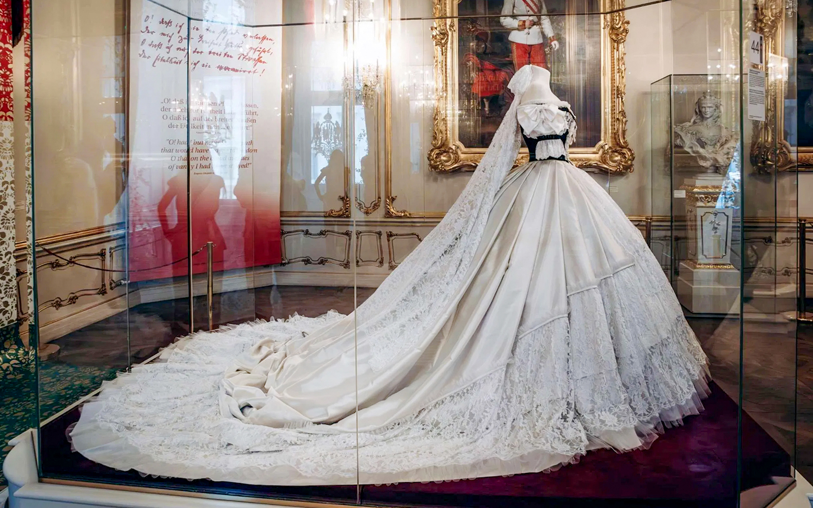 Dress on display at the Sisi Museum in Vienna, Austria, featuring intricate lace and a long train.