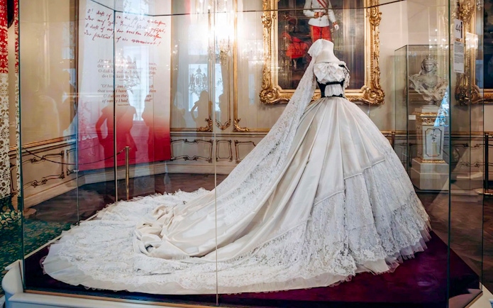 Dress on display at the Sisi Museum in Vienna, Austria, featuring intricate lace and a long train.