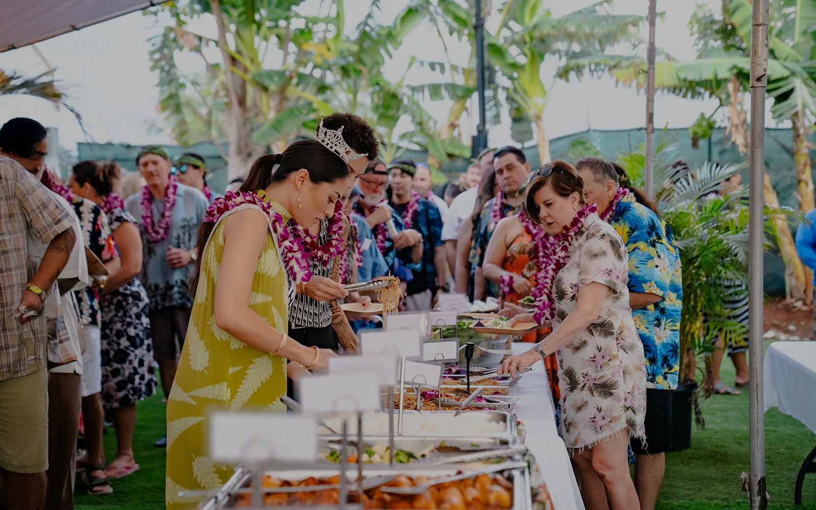 Guests serving themselves at a buffet of Polynesian food at Mauka Warriors Luau.