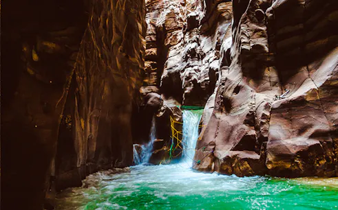 Wadi Mujib Siq Trail canyon with flowing water and rock formations, Amman.