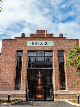 Roe & Co Distillery entrance with brick facade and large glass windows in Dublin.