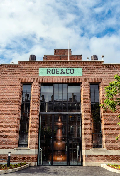 Roe & Co Distillery entrance with brick facade and large glass windows in Dublin.