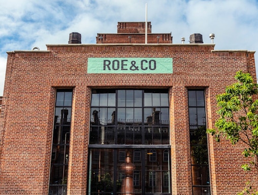 Roe & Co Distillery entrance with brick facade and large glass windows in Dublin.