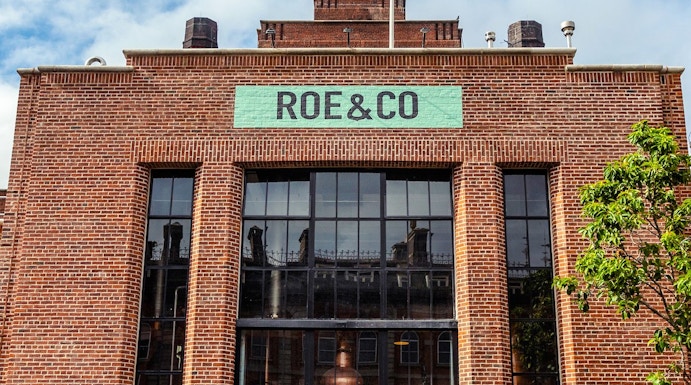 Roe & Co Distillery entrance with brick facade and large glass windows in Dublin.