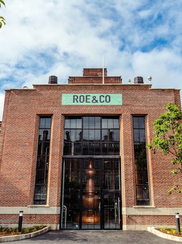 Roe & Co Distillery entrance with brick facade and large glass windows in Dublin.
