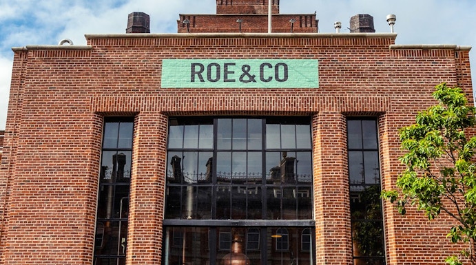 Roe & Co Distillery entrance with brick facade and large glass windows in Dublin.