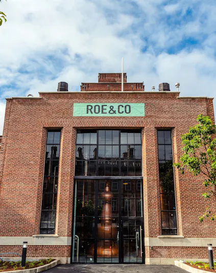 Roe & Co Distillery entrance with brick facade and large glass windows in Dublin.